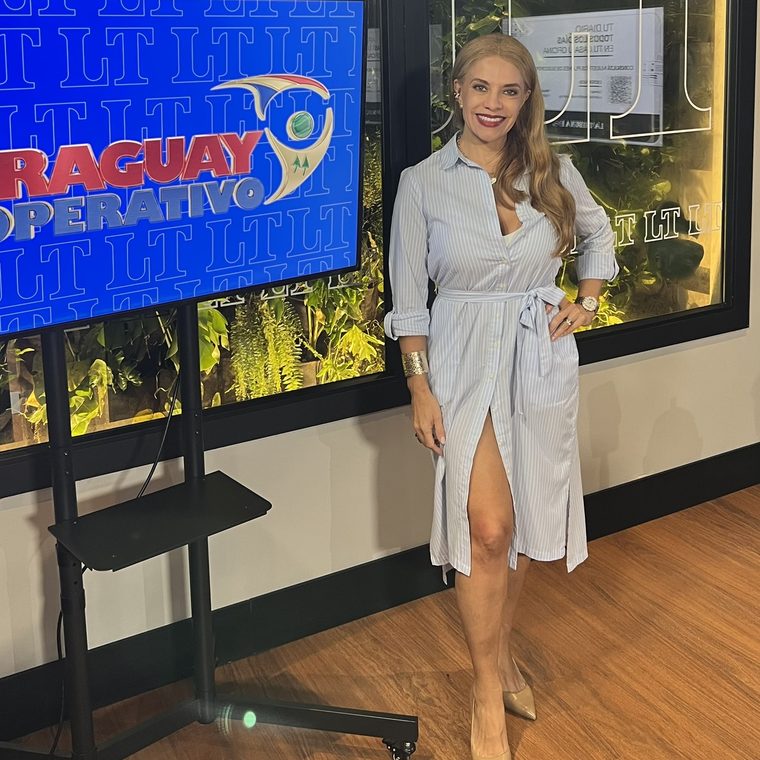 Cynthia Noguera junto a la pantalla con el logo de Paraguay Cooperativo