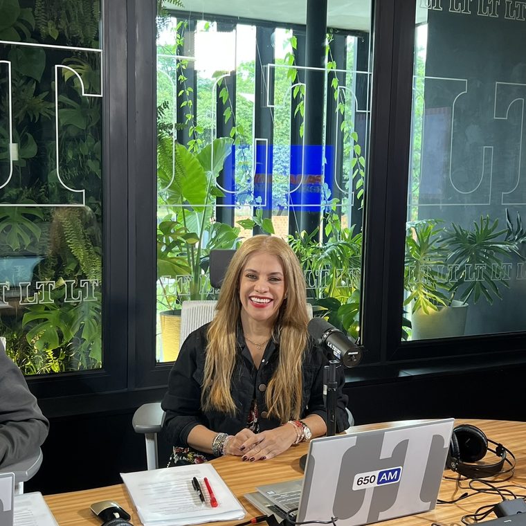 Cynthia Noguera frente al micrófono en la mesa de La Tribu 650 AM